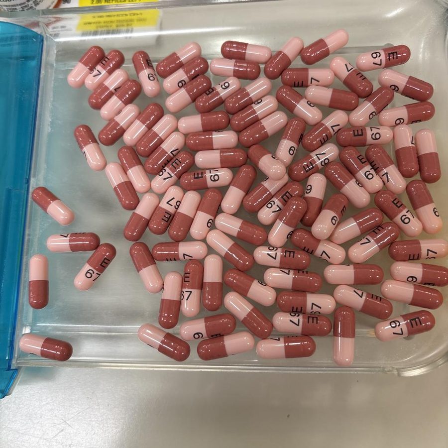 Pink capsules piled on top of each other on a tray