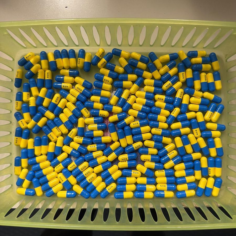 Hundreds of blue and yellow capsules filling a green basket