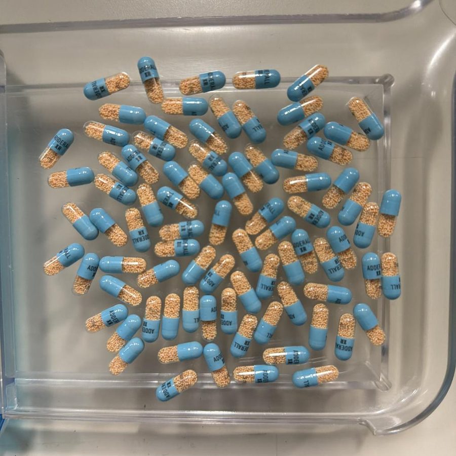 Eighty-five blue and orange capsules packed closely on a tray