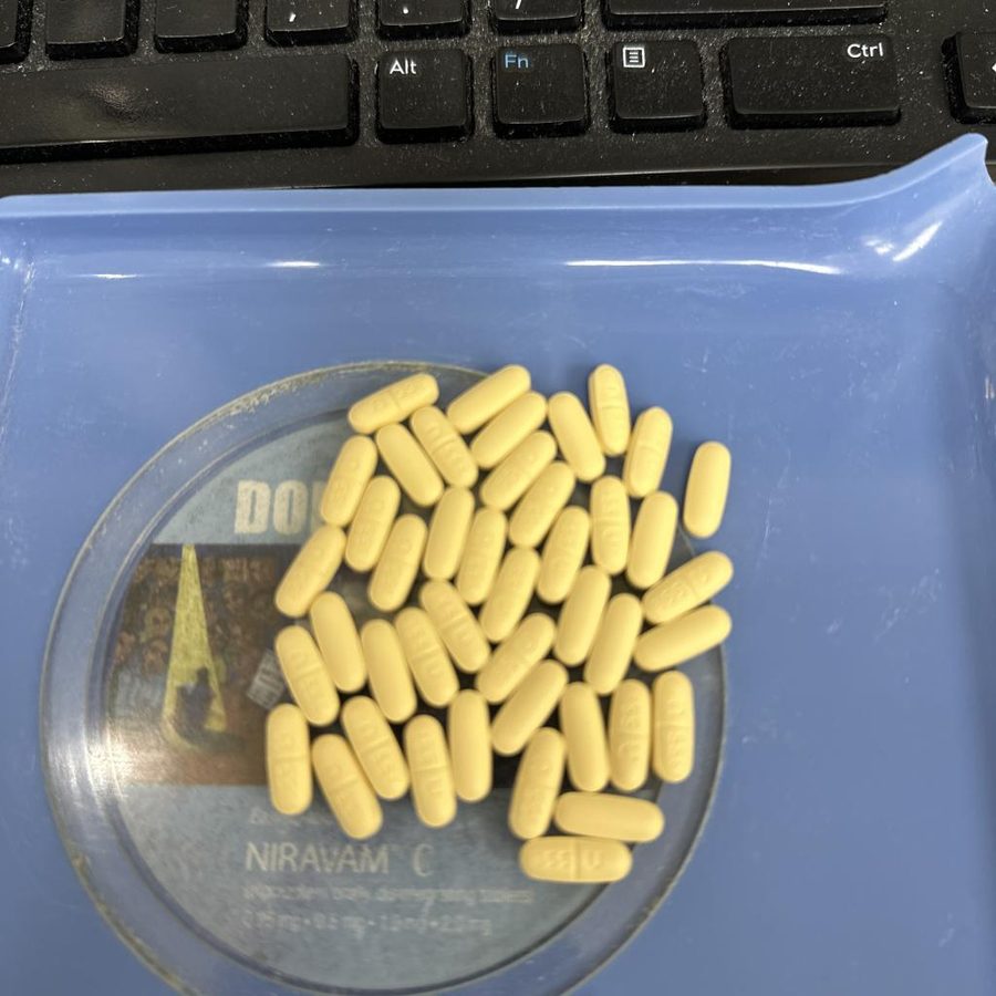 Yellow capsules on a printed coaster next to a keyboard