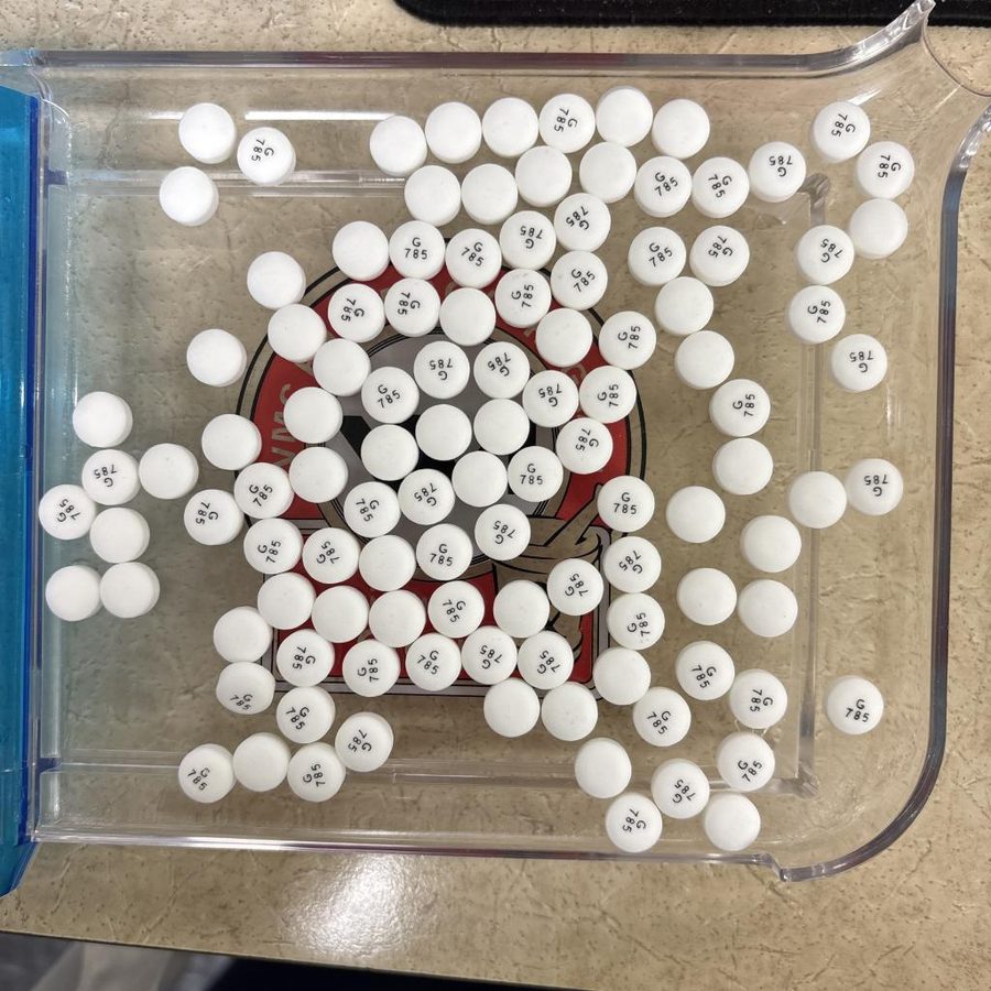 White tablets covering a red printed logo on the tray